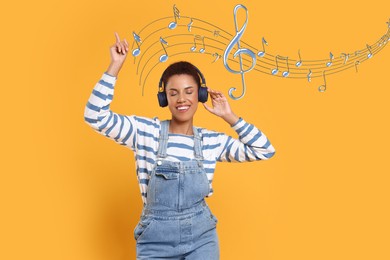 Image of Happy young woman with headphones dancing on orange background. Music notes flying near her