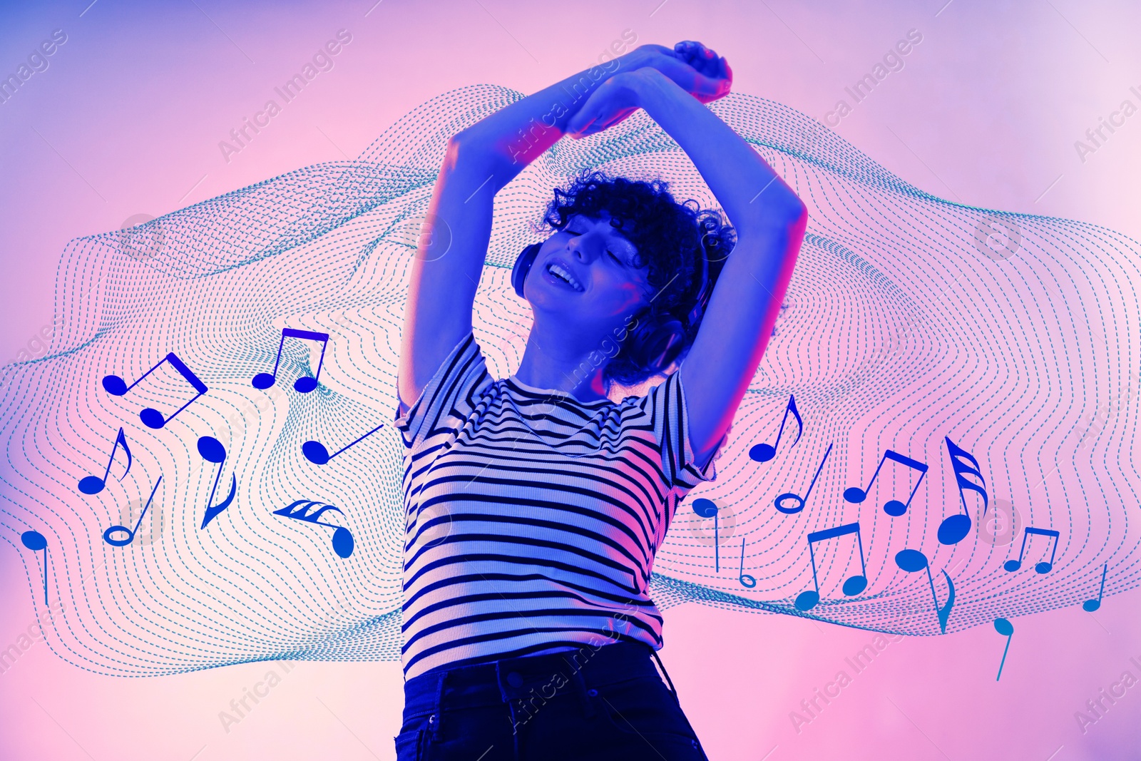 Image of Beautiful young woman with headphones on color background in neon lights, low angle view. Music notes flying near her