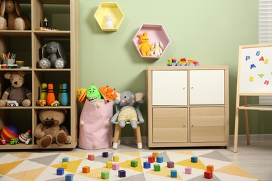 Photo of Colorful cubes on carpet and different toys in child's room