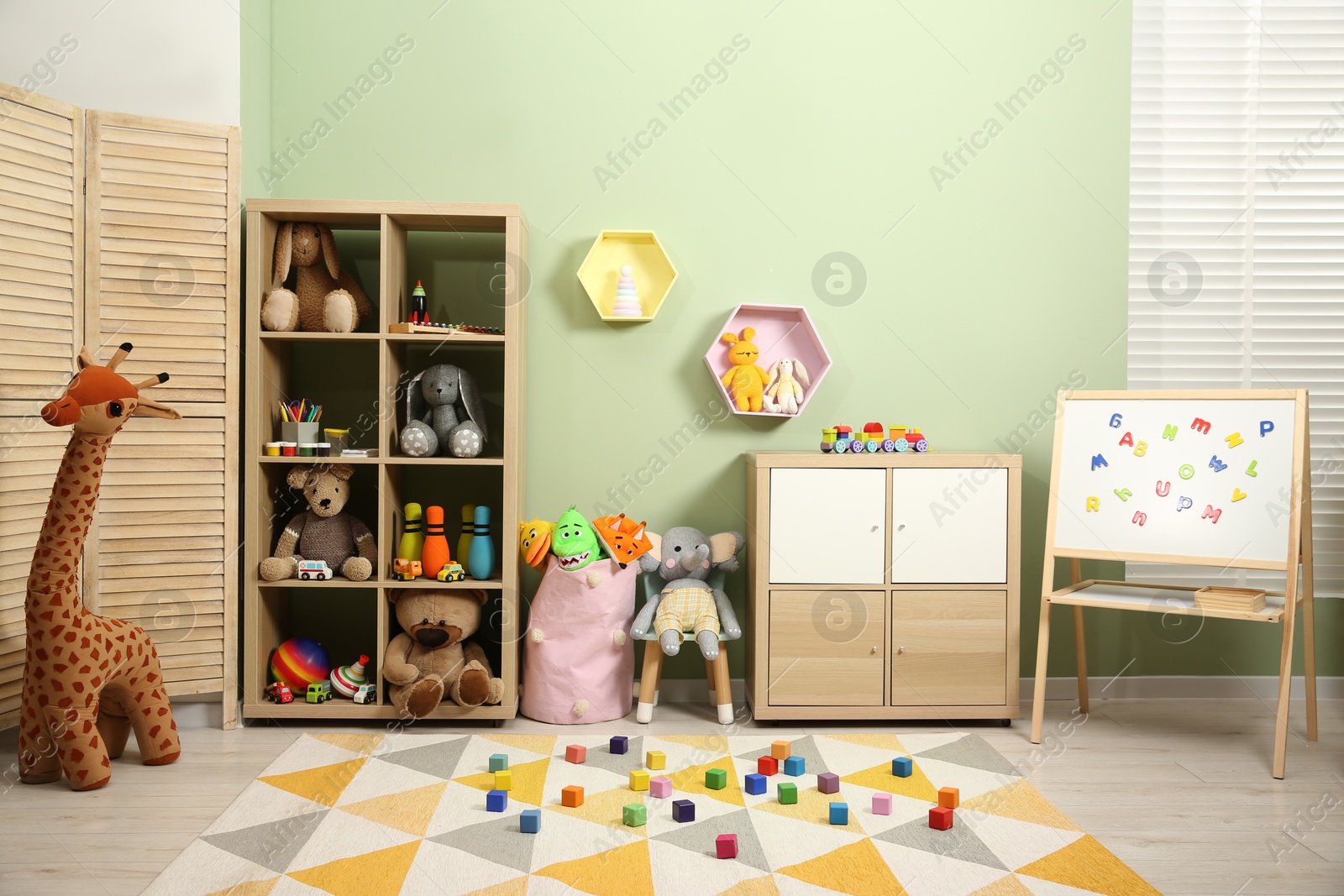 Photo of Colorful cubes on carpet and different toys in child's room