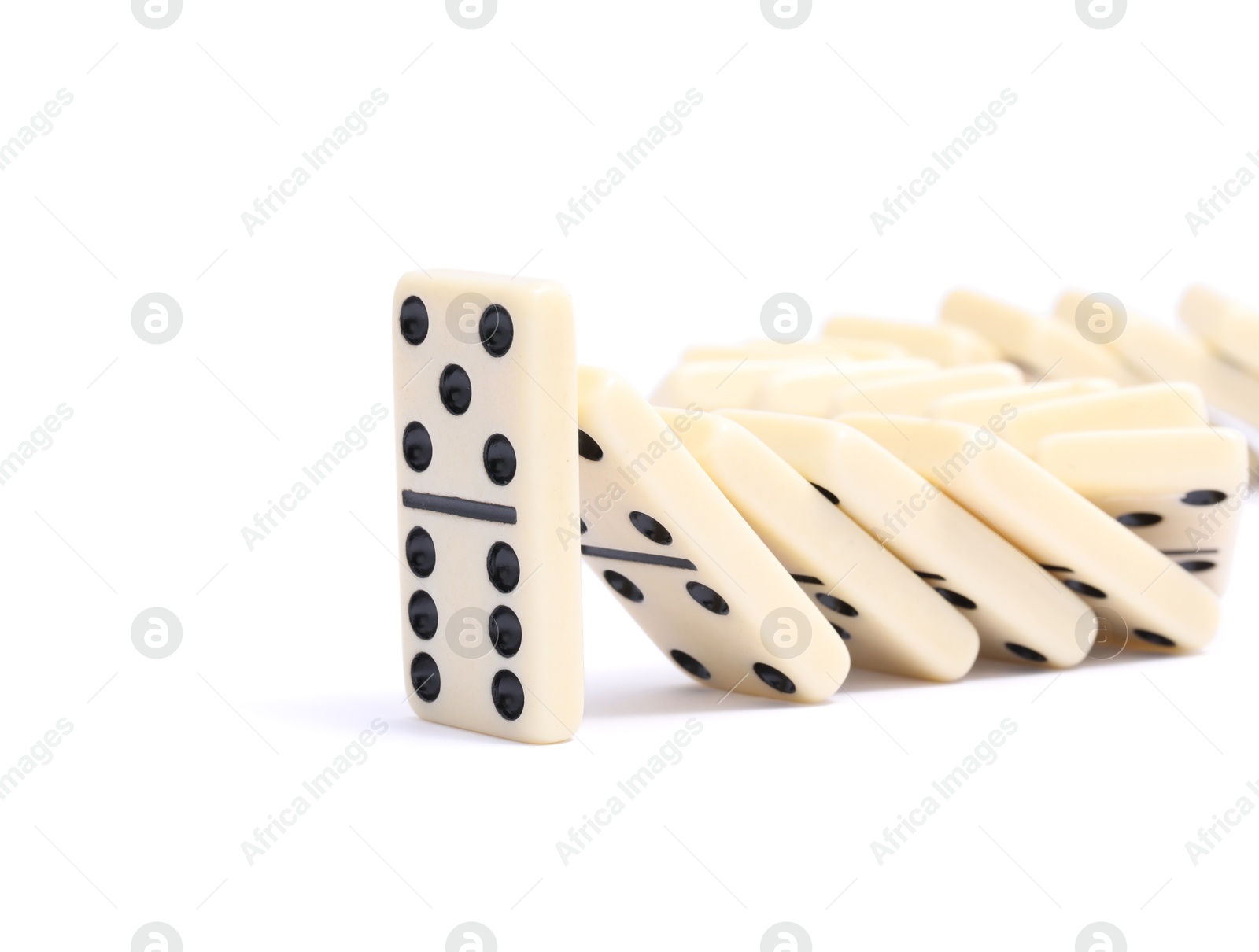 Photo of Domino effect. Tiles falling on white background