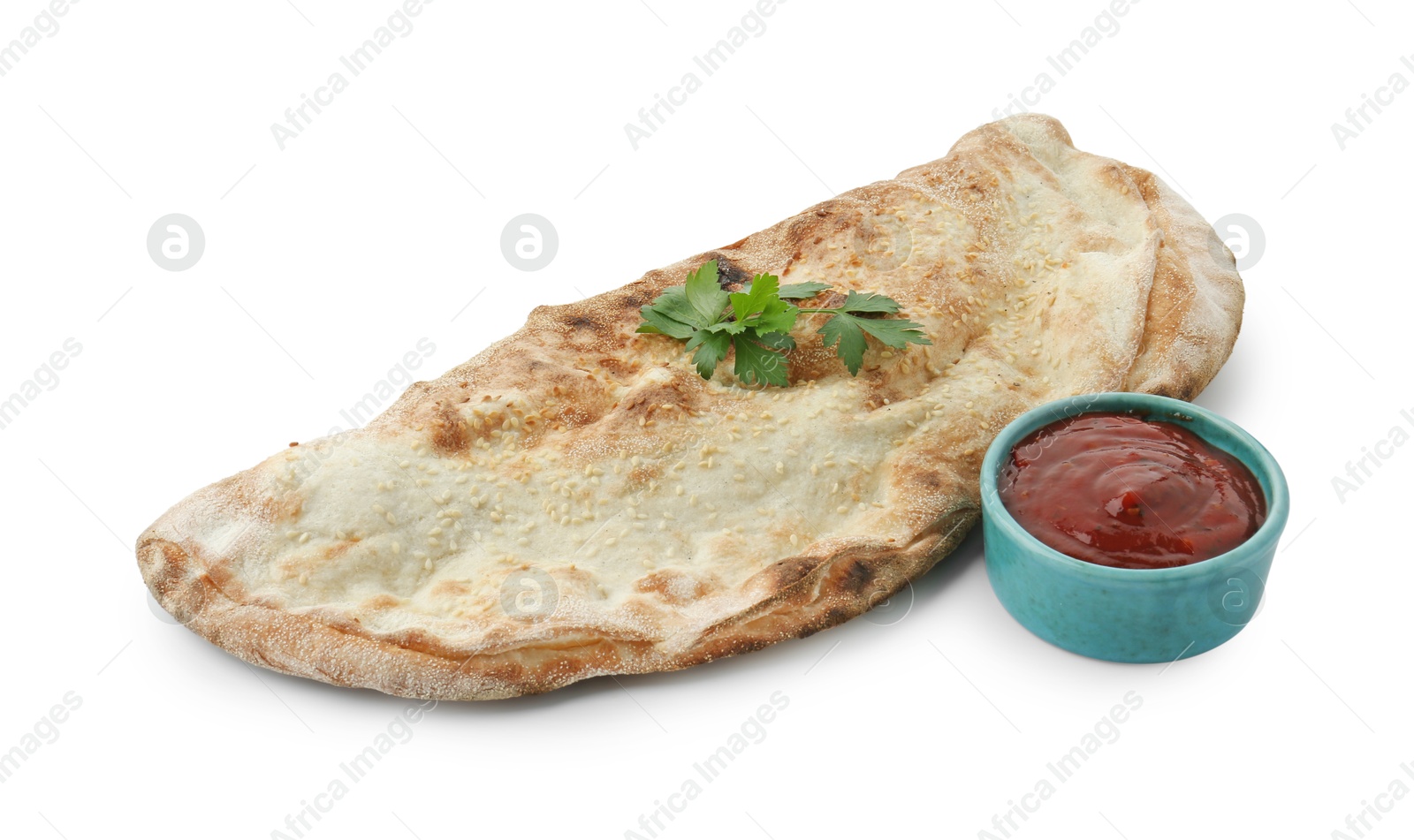 Photo of Delicious calzone with ketchup and fresh parsley isolated on white