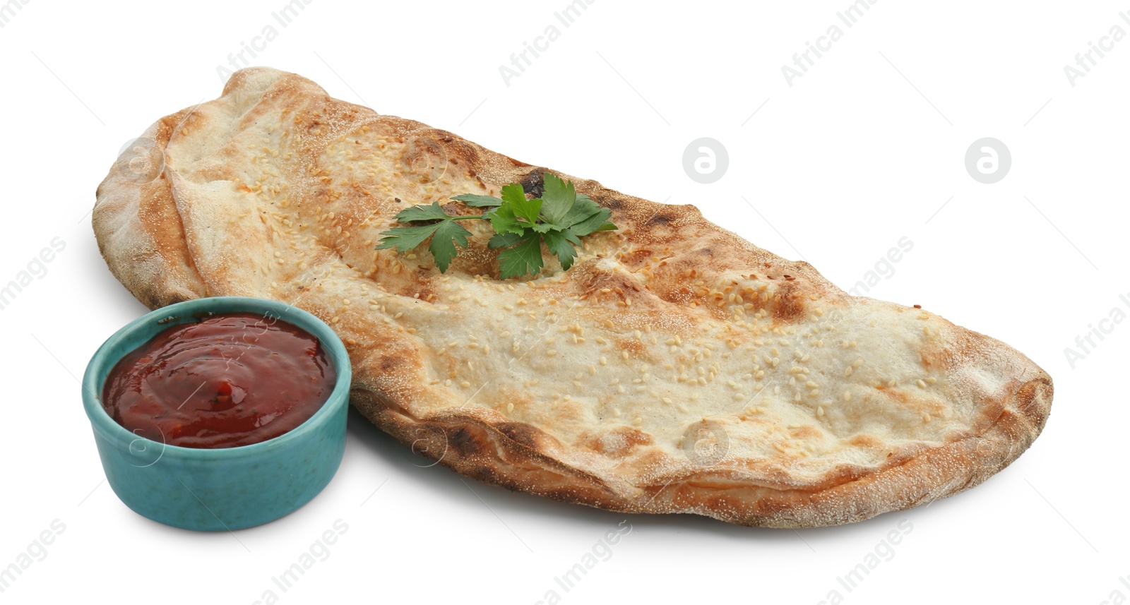 Photo of Delicious calzone with ketchup and fresh parsley isolated on white