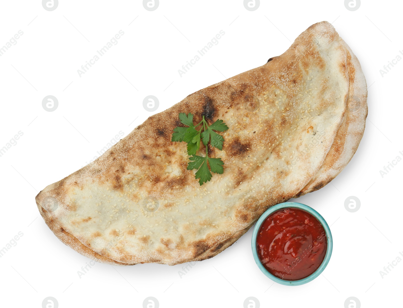 Photo of Delicious calzone with ketchup and fresh parsley isolated on white, top view