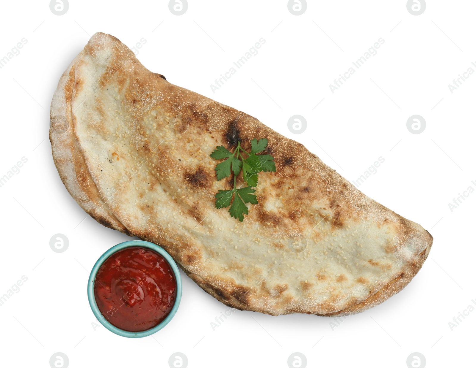 Photo of Delicious calzone with ketchup and fresh parsley isolated on white, top view