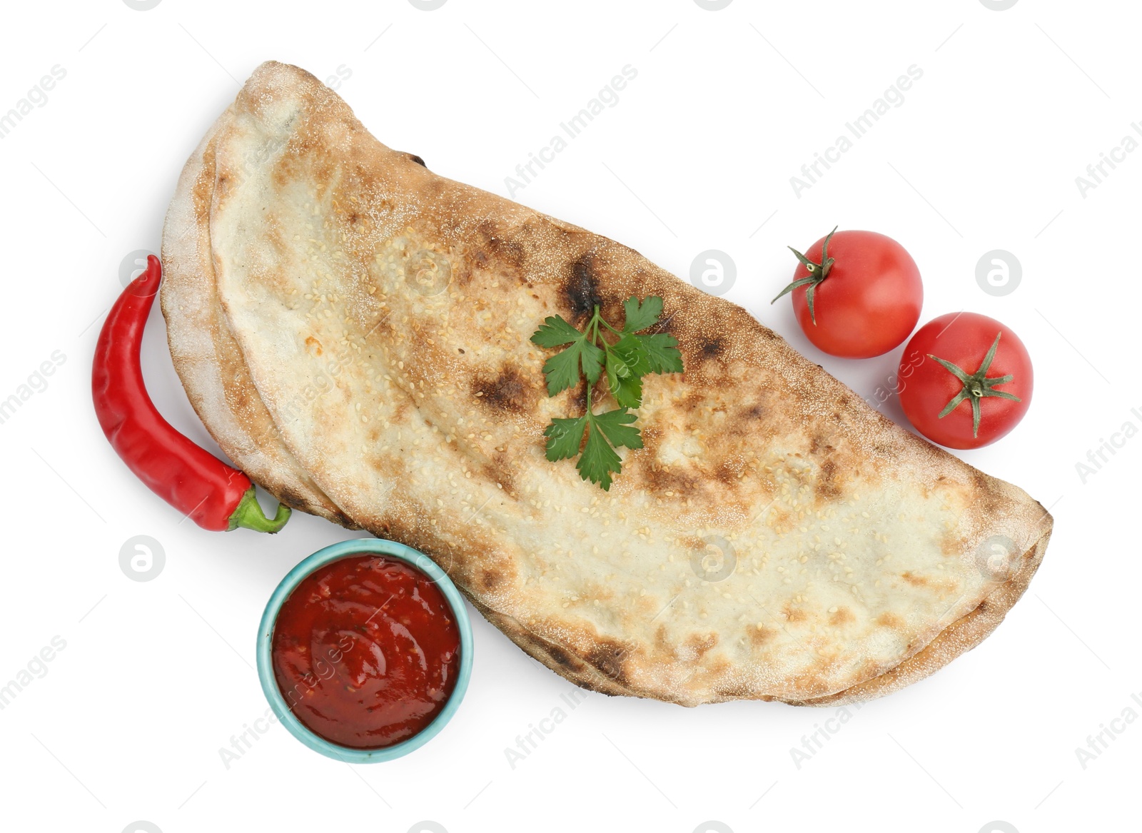 Photo of Delicious calzone with ketchup, fresh tomatoes and chili pepper isolated on white, top view