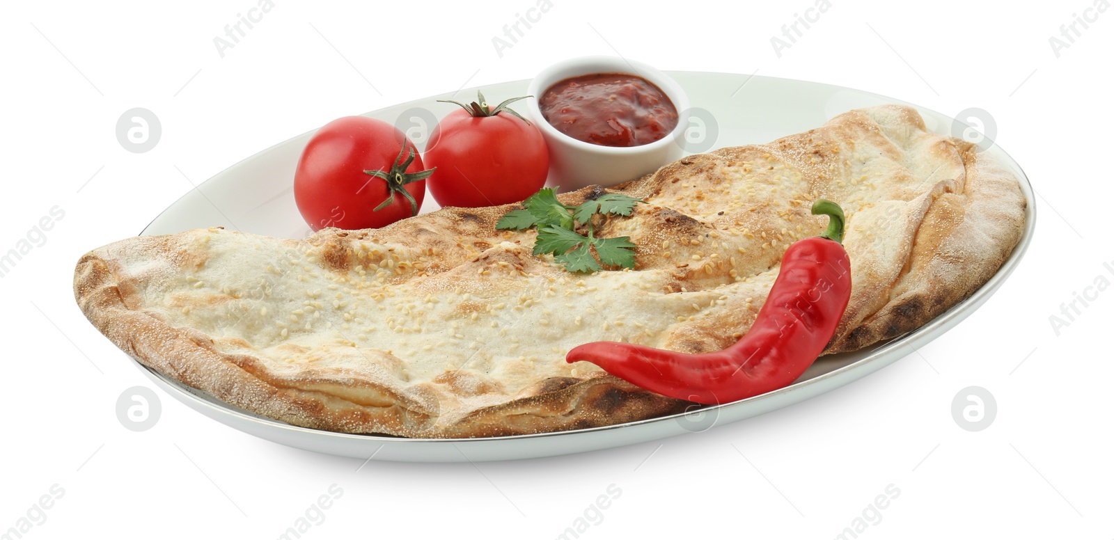 Photo of Delicious calzone with ketchup, fresh tomatoes and chili pepper isolated on white