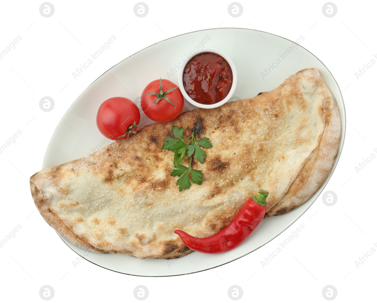 Photo of Delicious calzone with ketchup, fresh tomatoes and chili pepper isolated on white, top view