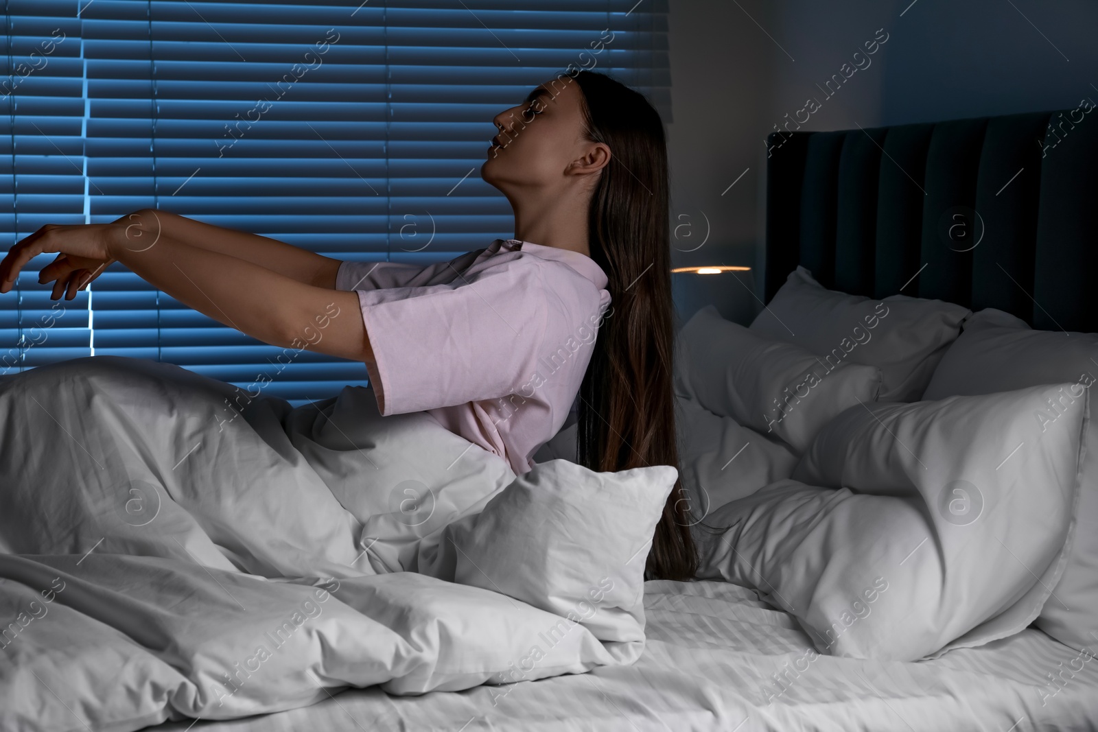 Photo of Young woman suffering from sleepwalking on bed at home