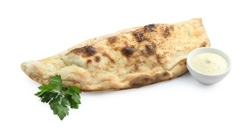 Photo of Delicious calzone with fresh parsley and sauce isolated on white