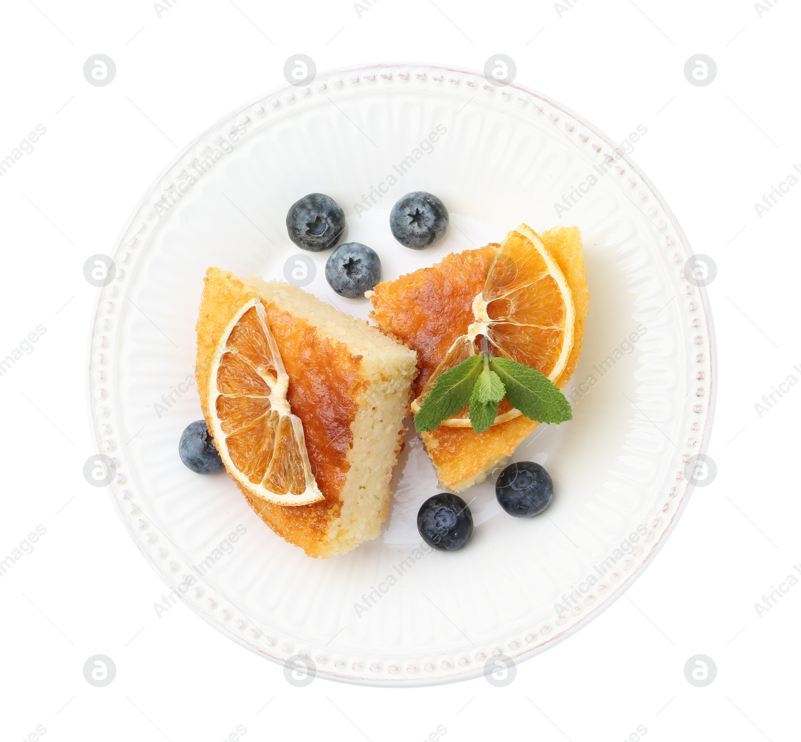 Photo of Pieces of delicious semolina cake with blueberries and orange slices isolated on white, top view