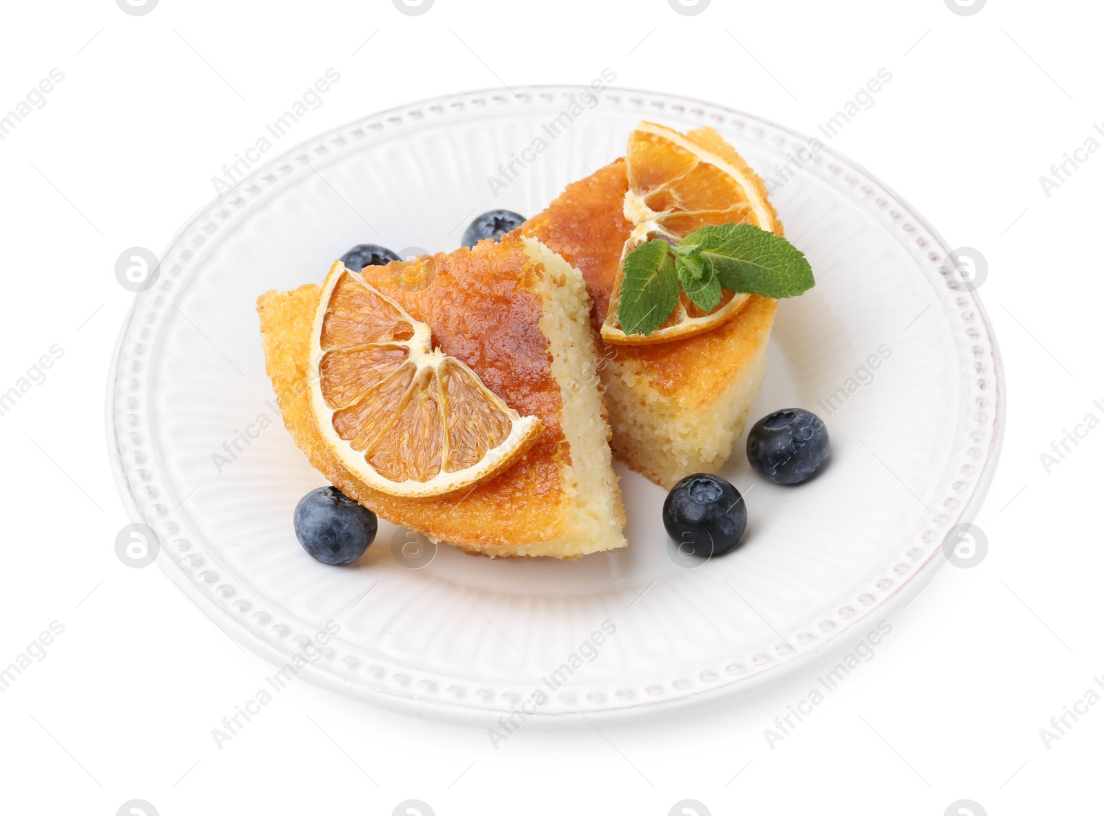 Photo of Pieces of delicious semolina cake with blueberries and orange slices isolated on white