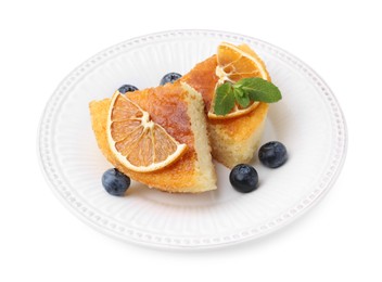 Photo of Pieces of delicious semolina cake with blueberries and orange slices isolated on white