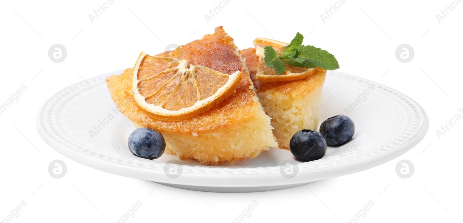 Photo of Pieces of delicious semolina cake with blueberries and orange slices isolated on white