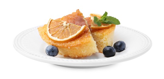 Photo of Pieces of delicious semolina cake with blueberries and orange slices isolated on white