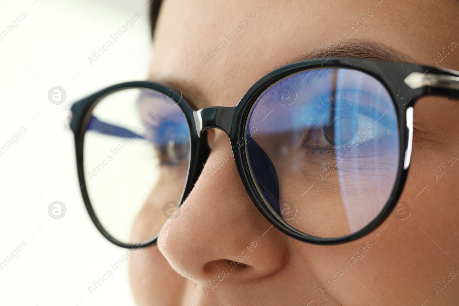 Photo of Woman wearing stylish glasses on blurred background, closeup