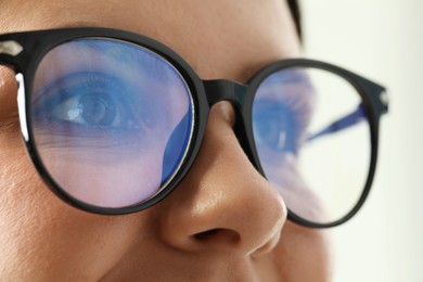 Photo of Woman wearing stylish glasses on blurred background, closeup