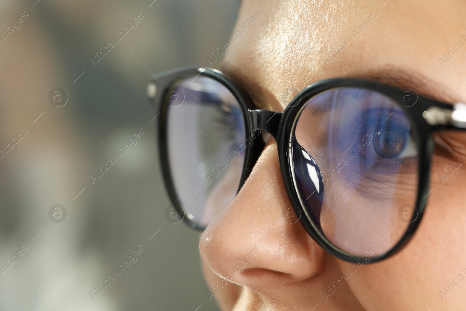 Photo of Woman wearing stylish glasses on blurred background, closeup