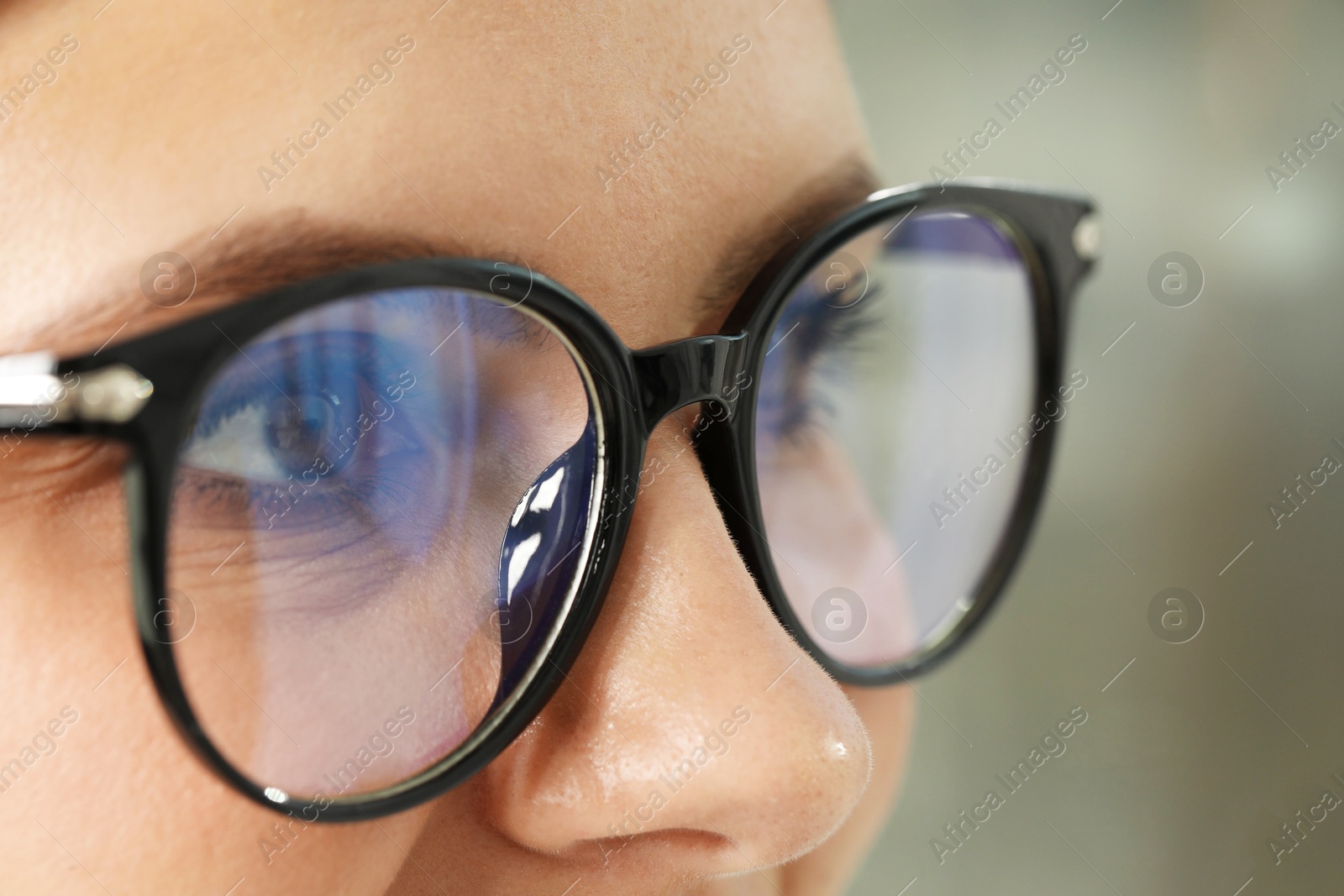 Photo of Woman wearing stylish glasses on blurred background, closeup