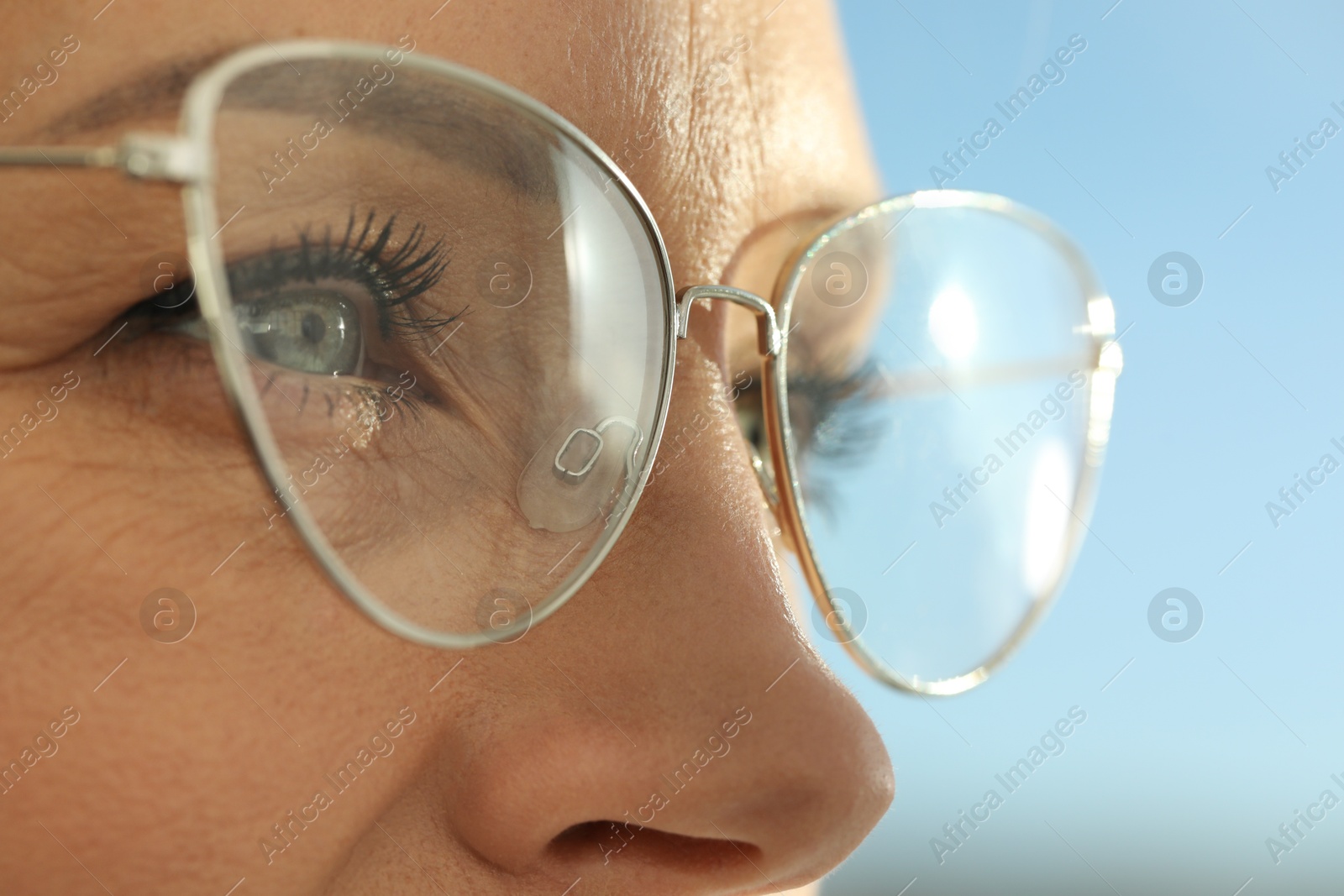 Photo of Woman wearing stylish glasses on blurred background, closeup