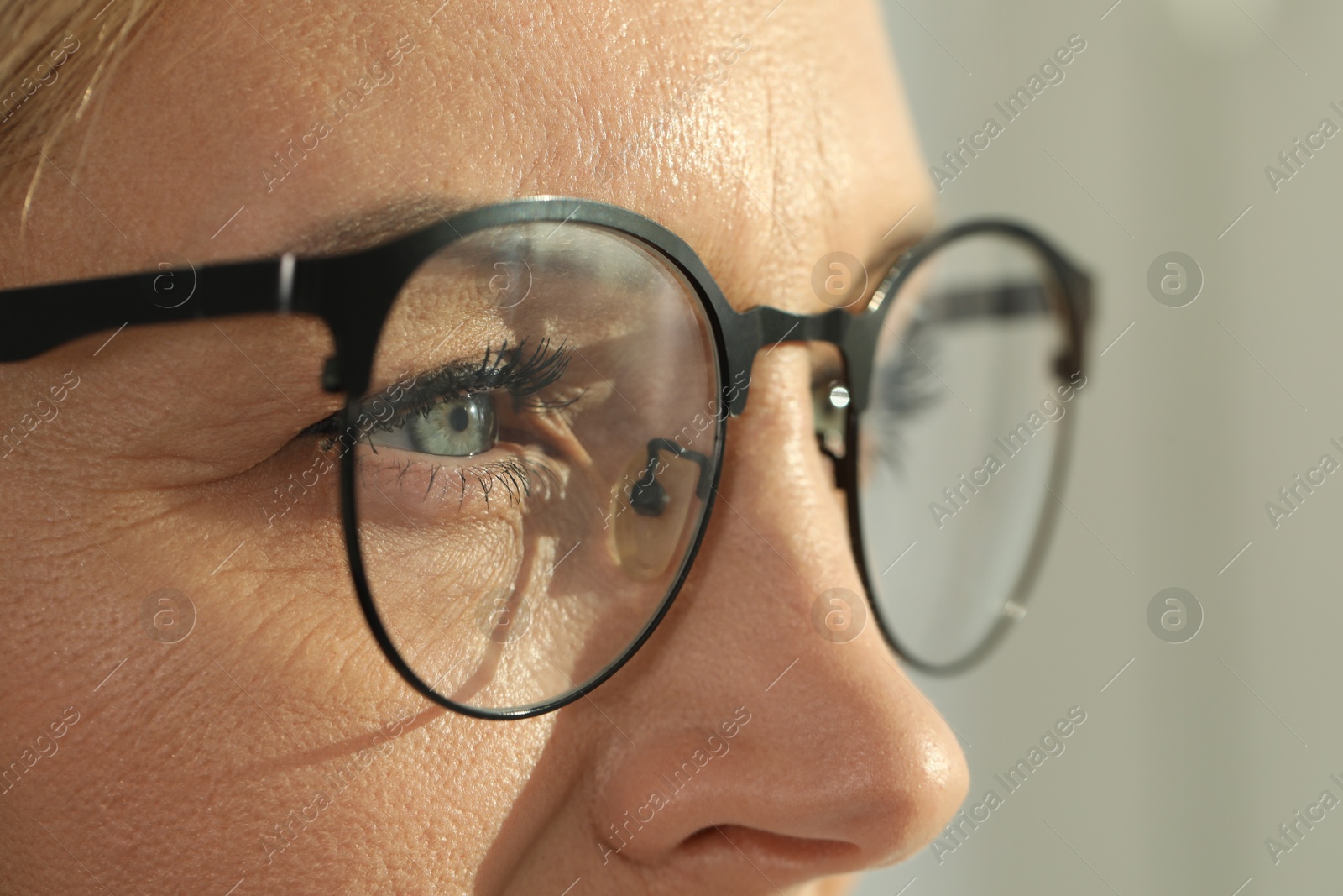 Photo of Woman wearing stylish glasses on blurred background, closeup