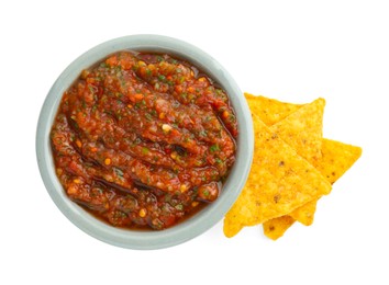 Photo of Tasty salsa sauce in bowl and tortilla chips isolated on white, top view