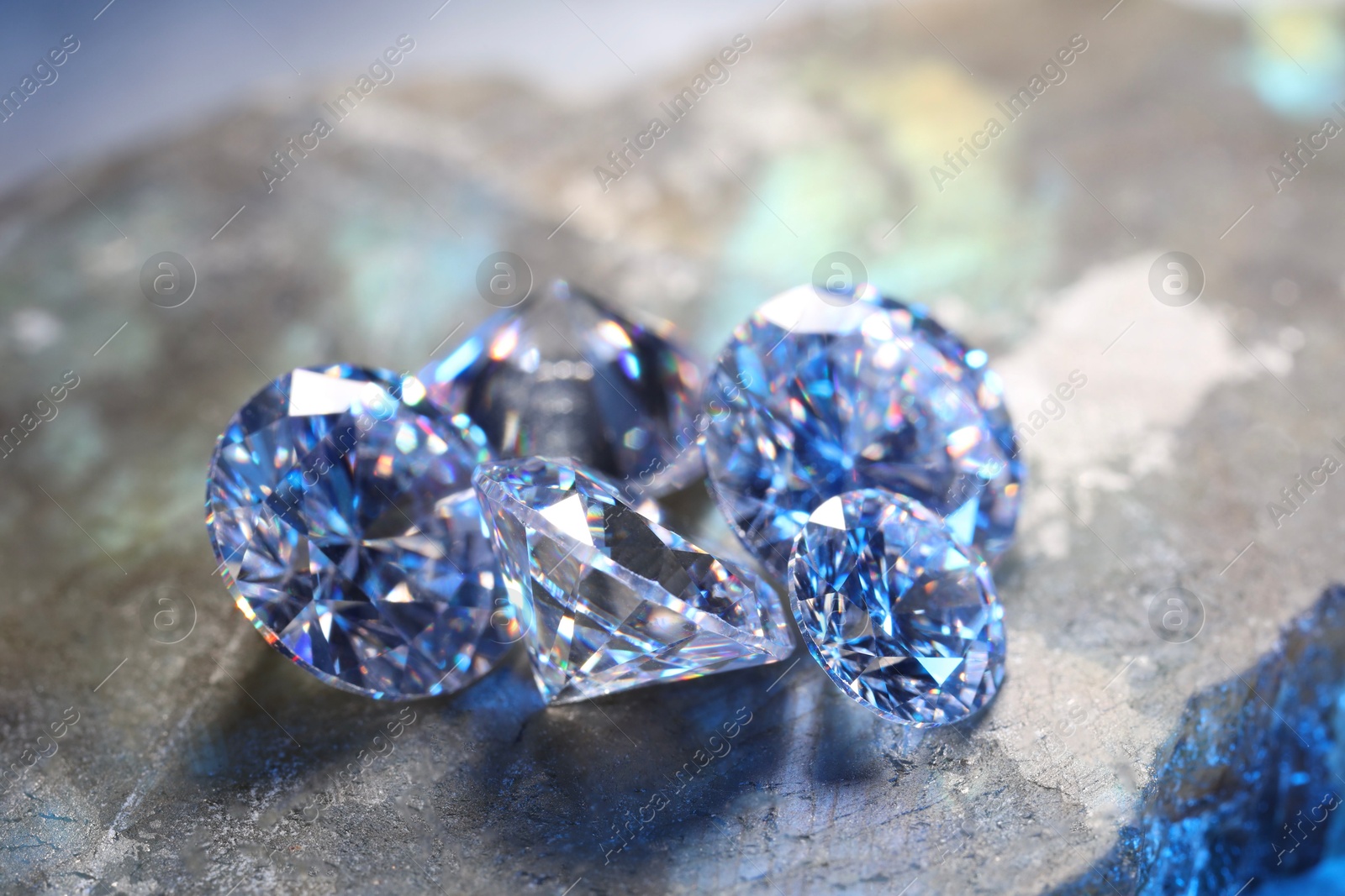 Photo of Beautiful shiny gemstones on stone, closeup view