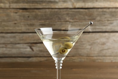 Photo of Martini cocktail with olives in glass on table, closeup