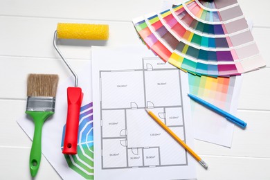 Photo of Designer's workplace with color palettes, floor plan and different supplies on white wooden table, flat lay