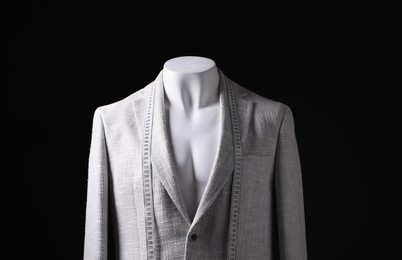 Photo of Male mannequin with grey jacket and measuring tape on black background