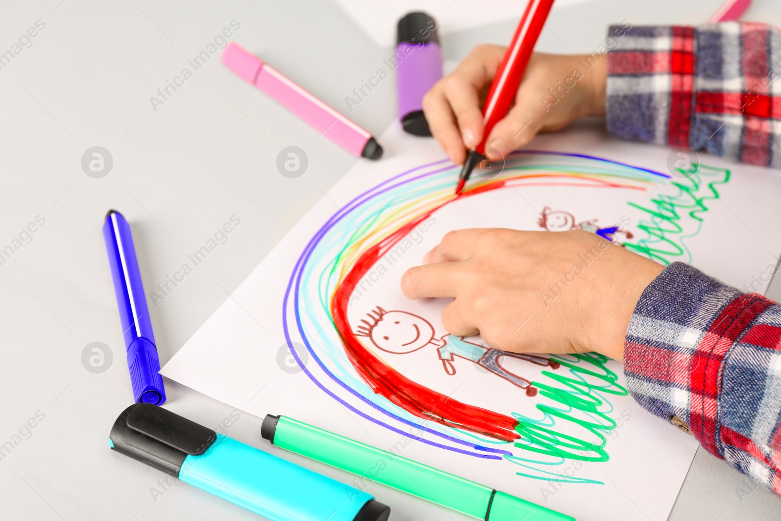 Photo of Boy drawing his family at light table, closeup