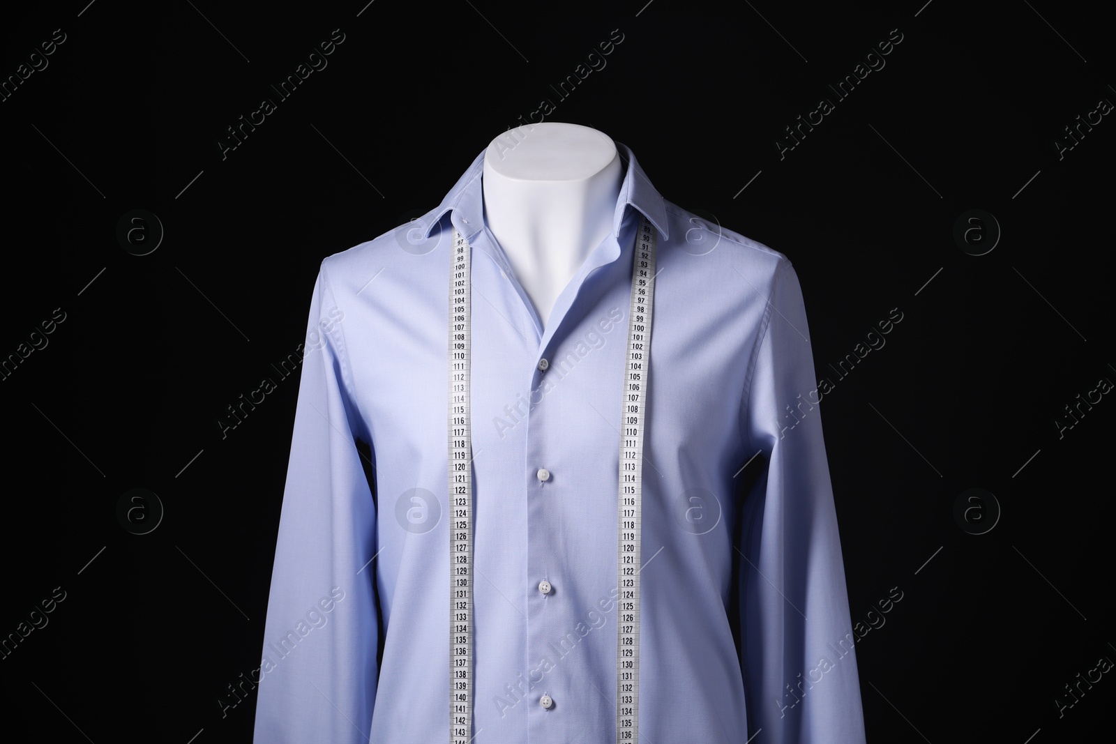 Photo of Male mannequin with light blue shirt and measuring tape on black background