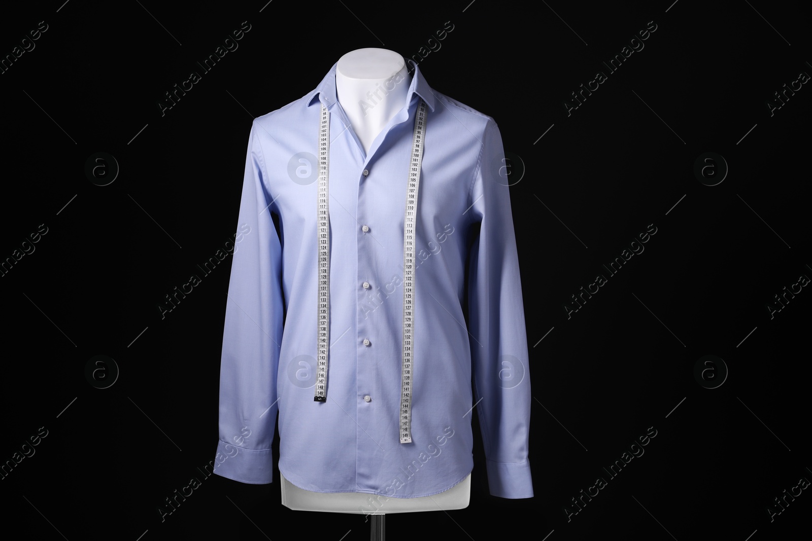 Photo of Male mannequin with light blue shirt and measuring tape on black background