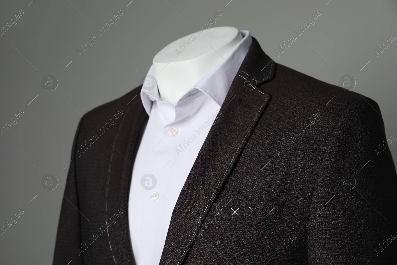 Photo of Semi-ready jacket and white shirt on mannequin against grey background, closeup