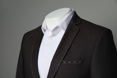 Photo of Semi-ready jacket and white shirt on mannequin against grey background, closeup