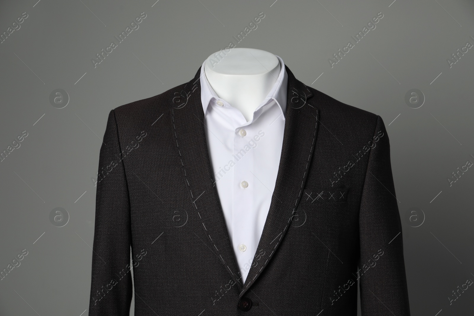 Photo of Semi-ready jacket and white shirt on mannequin against grey background