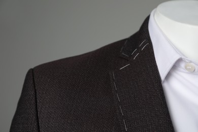 Photo of Semi-ready jacket and white shirt on mannequin against grey background, closeup