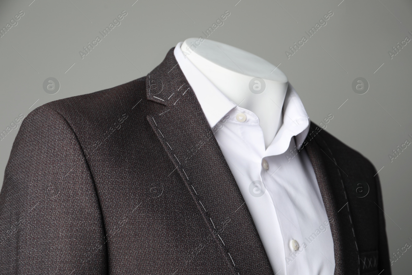 Photo of Semi-ready jacket and white shirt on mannequin against grey background, closeup