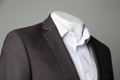 Photo of Semi-ready jacket and white shirt on mannequin against grey background, closeup