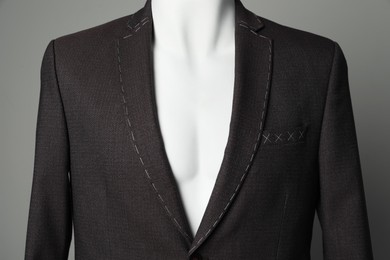 Photo of Semi-ready jacket on mannequin against grey background, closeup