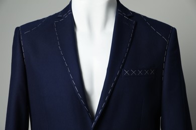 Photo of Semi-ready jacket on mannequin against grey background, closeup