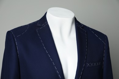 Photo of Semi-ready jacket on mannequin against grey background, closeup