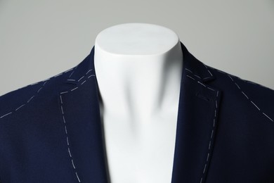 Semi-ready jacket on mannequin against grey background, closeup