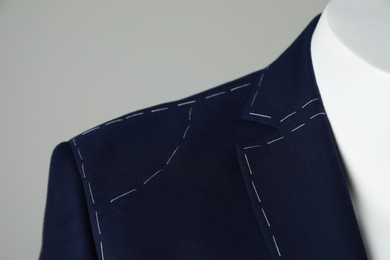 Photo of Semi-ready jacket on mannequin against grey background, closeup