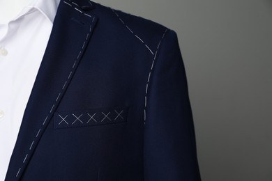 Photo of Semi-ready jacket and white shirt on mannequin against grey background, closeup