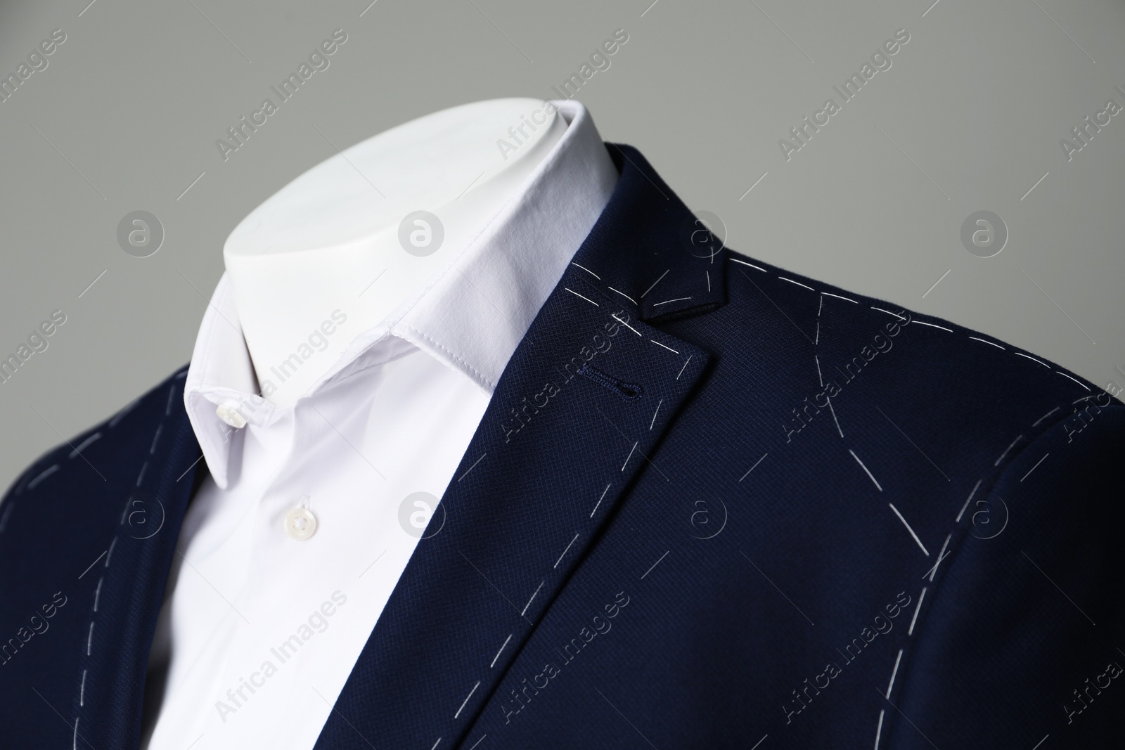 Photo of Semi-ready jacket and white shirt on mannequin against grey background, closeup