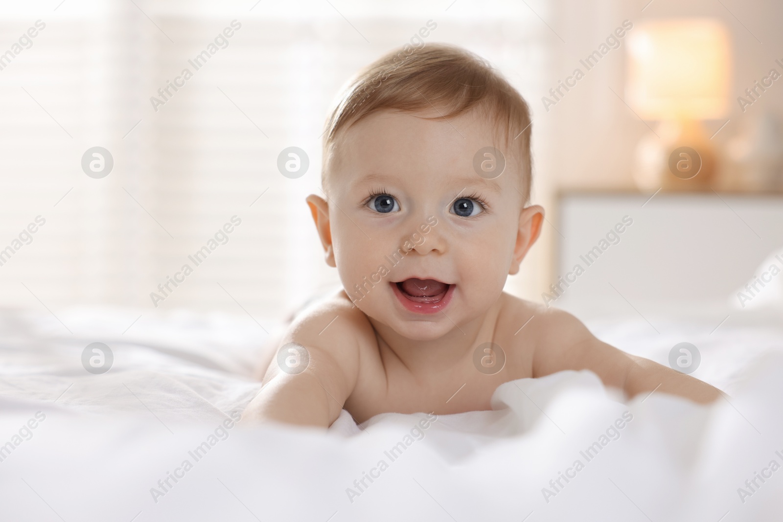 Photo of Cute baby lying on bed at home