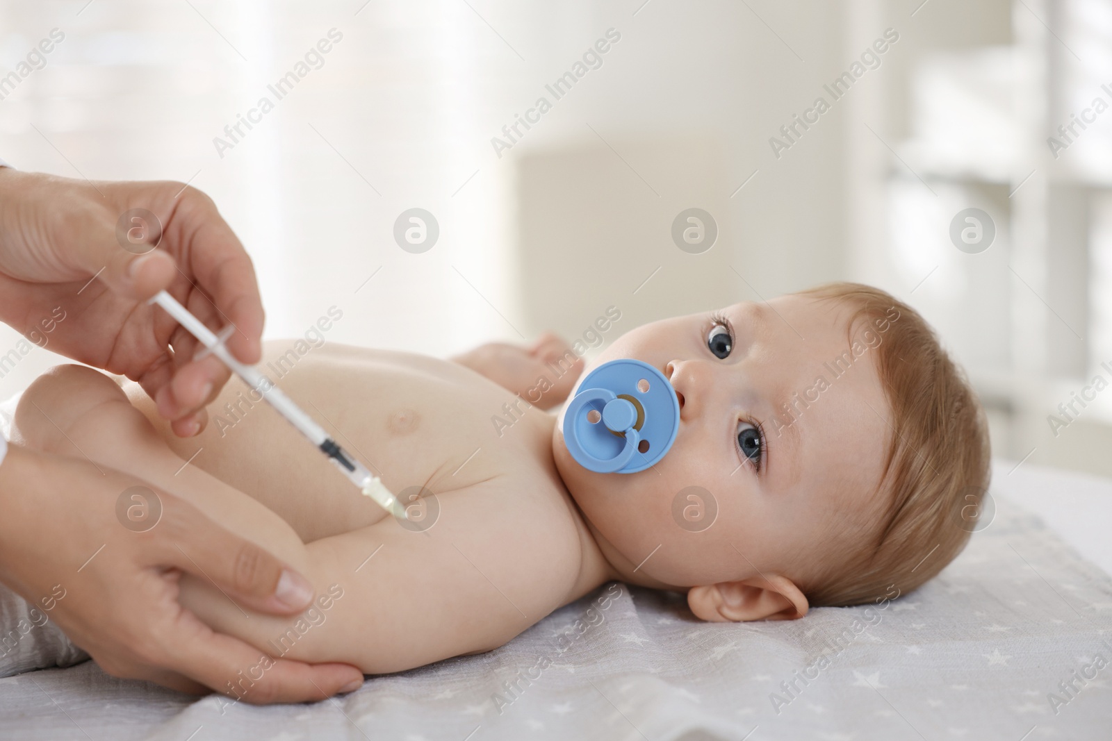 Photo of Pediatrician giving injection to cute baby in clinic, closeup