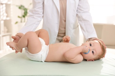 Photo of Pediatrician with little child in clinic, closeup. Checking baby's health