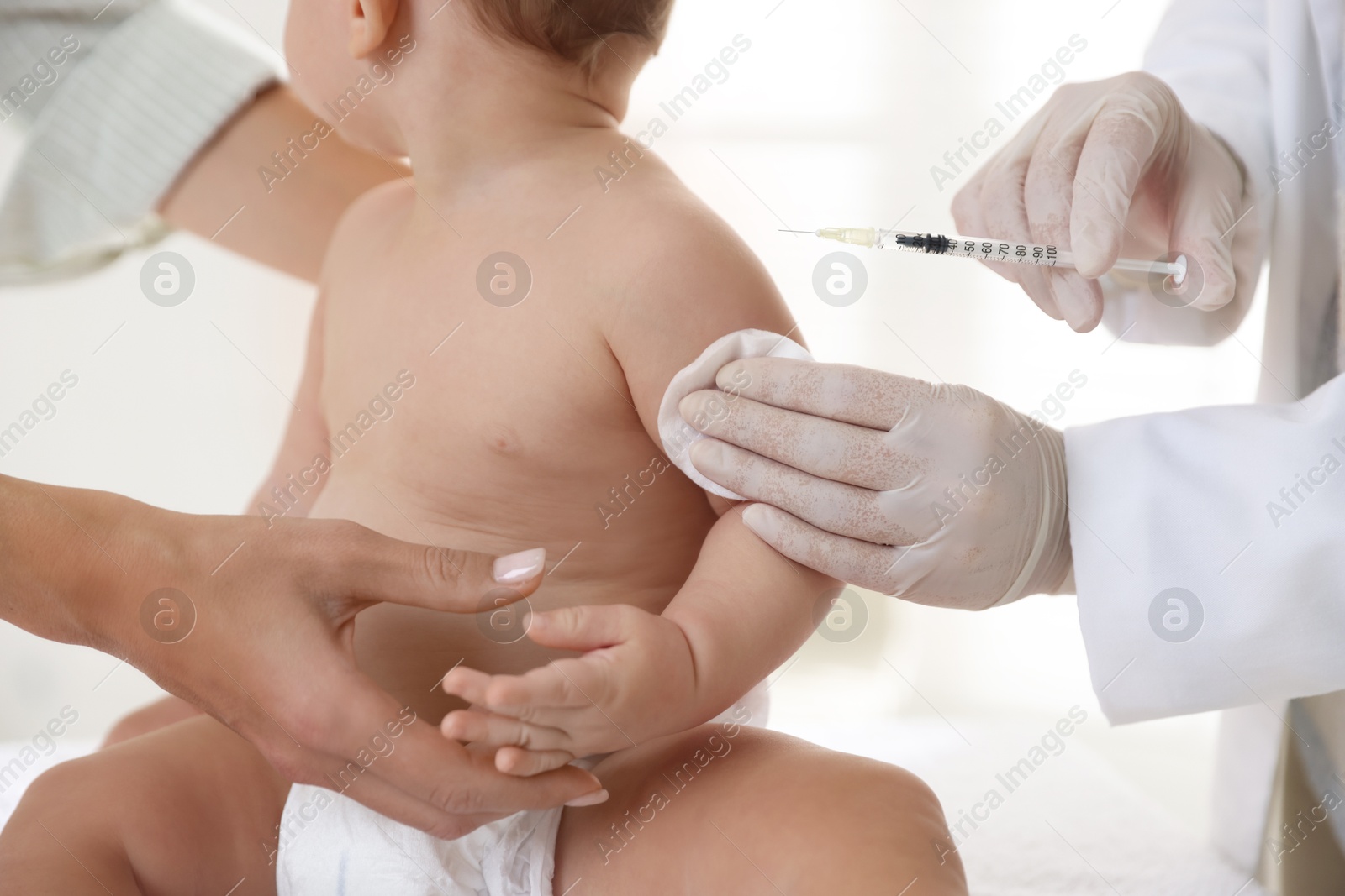 Photo of Pediatrician vaccinating little baby in clinic, closeup